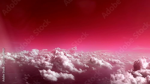 Flying through the clouds aerial view from airplane red sky