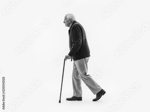 Elderly man walking with cane outdoors