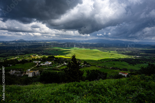 Green valley with wind turbines under dramatic storm clouds, Andalusia, Spain