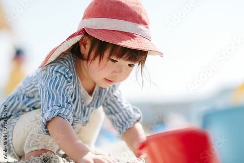 こども園・幼稚園・保育園の園庭で砂場遊びをする日本人の幼児