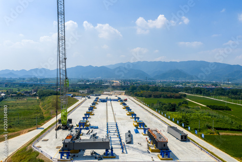 Aerial view of large-scale bridge prefabricated component construction site with cranes and assembly lines