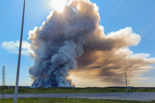 Smoke from a fire rises into the sky. Thick smoke obscures the sky and sun in rural areas.