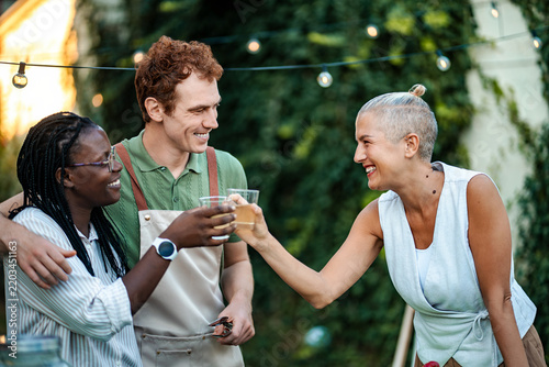 Принти на полотні Celebrating friendship with drinks in a vibrant outdoor setting