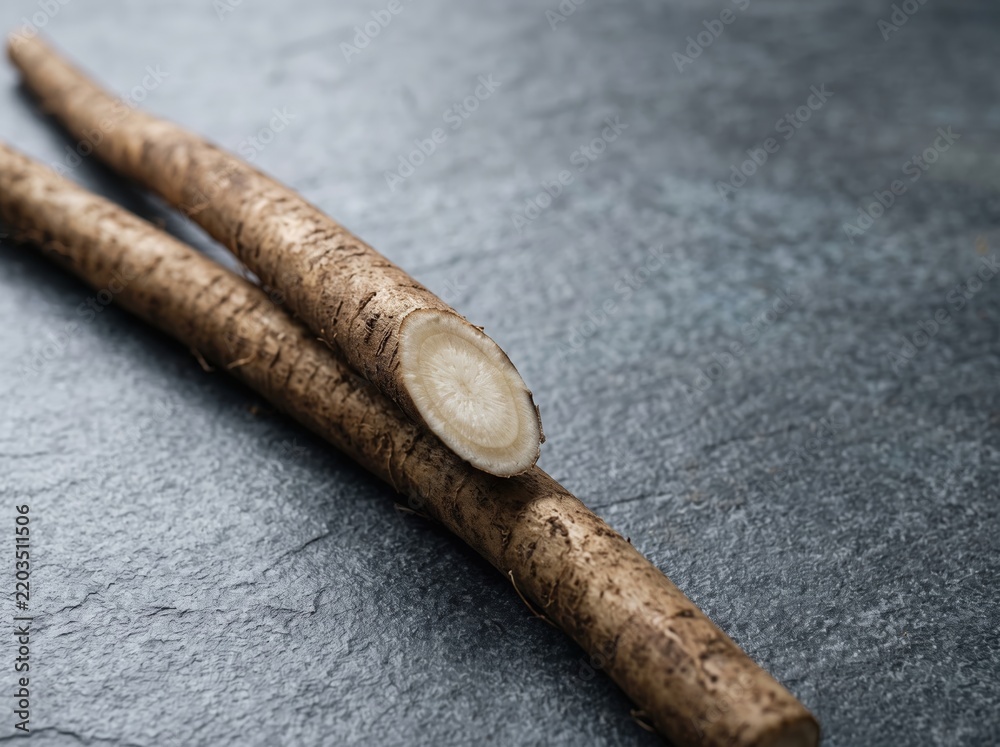 Obraz premium Burdock roots sliced on dark stone kitchen countertop