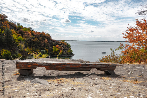 Wooden bench on the beach of a recreational destination by the lake in the park