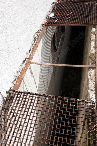 Missing section of metal grating flooring for safe passage over the floor shaft.