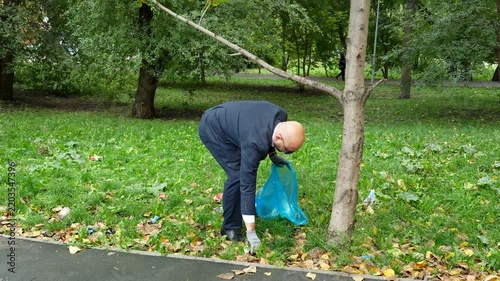 Businessman collecting trash in a city park