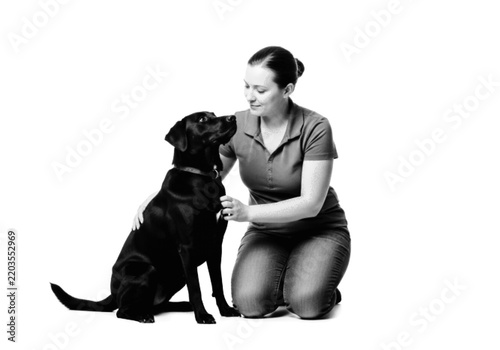 Woman sitting with black dog looking affectionate Vector, illustration