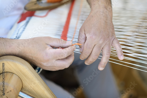 Hands Working Warp Threads on a Wooden Handloom
