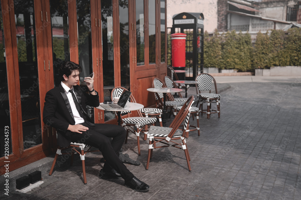 Obraz premium Man Relaxing Beside Bicycle At Outdoor Cafe On Urban Street.