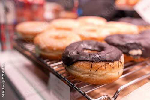 Chocolate doughnut on display at a bakery, tempting sweet treats and pastries