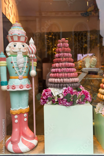 Christmas nutcracker figure and macaron pyramid in a bakery window display