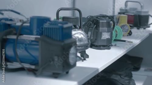 Samples of new 12-volt automotive tire pumps are on display at the exhibition. Closeup. Shot in motion. Follow focus
