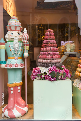 Elegant pastry shop storefront featuring colorful macaron towers and artisan desserts