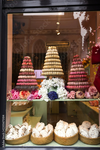Elegant pastry shop storefront featuring colorful macaron towers and artisan desserts