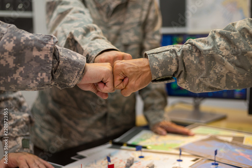 Experienced military hands focused intensely around a tactical map table, actively collaborating and planning precise strategic operations, operational logistics