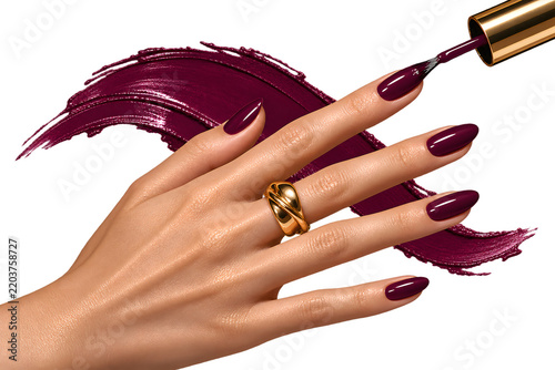 Manicured female hand holding an object isolated on white background with elegant red nails and modern beauty styling.