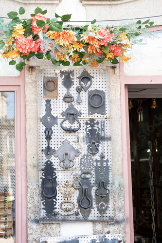 Collection of rustic iron door knockers on a display board.