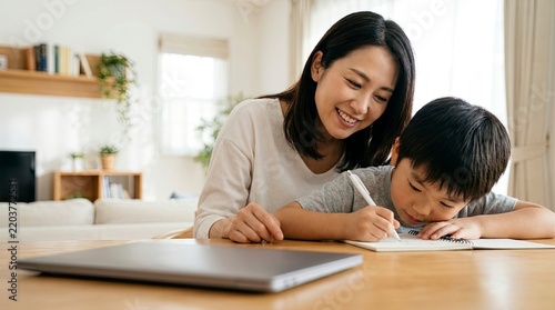 Happy Asian Mother and Child Doing Homework Together.