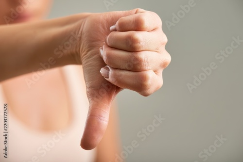 Thumbs-down hand gesture: a tight close-up capturing disapproval and negative feedback