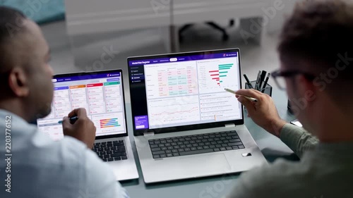 Data Analyst And Manager Review AI Model Risk On Laptop