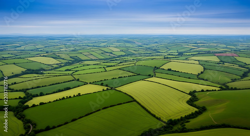 Green Hills and Valleys Patchwork Fields Under Blue Sky Aerial View Agricultural Patterns