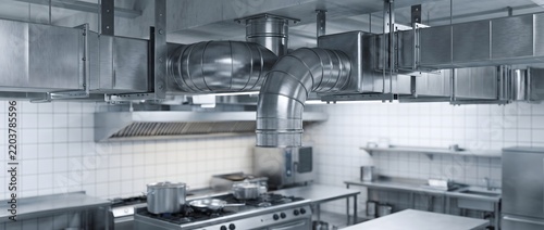 Industrial kitchen ventilation system with stainless steel exhaust ducts.
