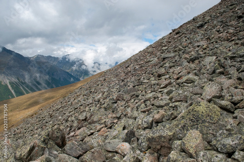 Picturesque slopes of the Pyramid mountain covered with huge boulders in the foreground, Russia, the Altai Republic