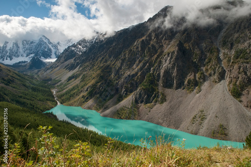 Landscape view of the Lower Shavlinsky lake, glacial lake with turquoise and emerald waters surrounded by the Altai mountains, Russian Federation