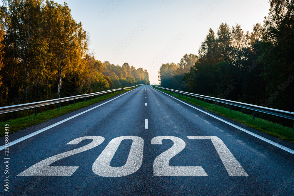 Obraz premium Asphalt highway between forests with the new year 2027 painted on pavement for future planning concepts.
