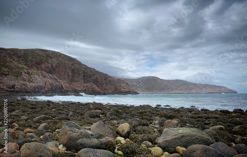 Rocky shoreline of the Arctic Ocean bay under stormy coastal clouds, Teriberka, Russia, June 2019