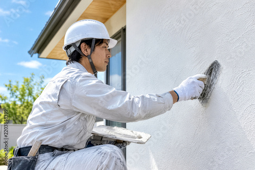 Plakat 住宅の外壁を左官作業でならす職人