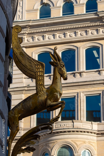 Fotografie Close up of a golden winged goat statue ornament on a building near Charing Cros