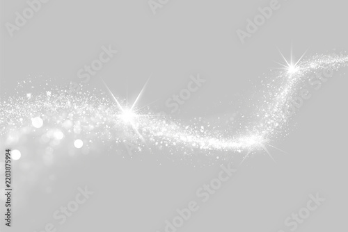 A swirling trail made of sparkling silver glitter stretches across a dark background. Bright stars accent the flowing curved path of shimmering particles. The elegant glitter trail sparkles.