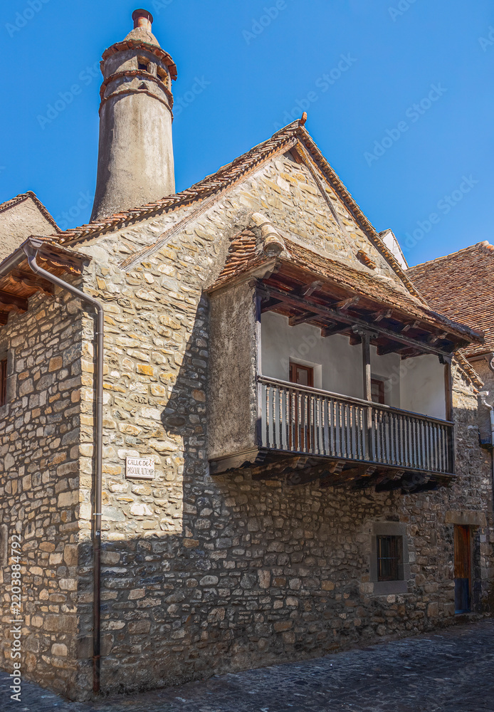 Fototapeta premium casa tipica del pirineo oscense con gran chimenea, balcon de madera y calles empedradas en Ansó, Huesca, España