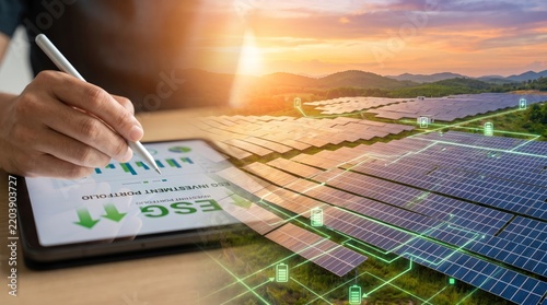 Hand Using Stylus on Digital Tablet Overlaid on Large Solar Panel Farm at Sunset