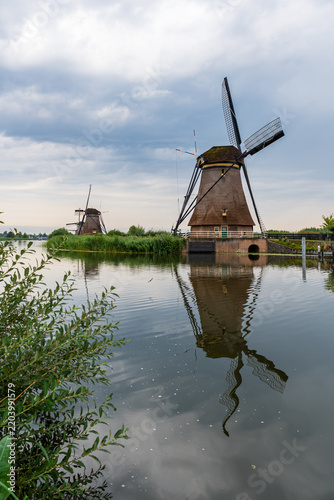 Ancient windmills facade reflected on water in Kinderdijk