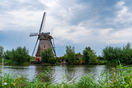 Ancient windmill at a river bank in Kinderdijk