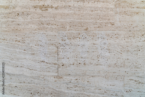 Light travertine tile wall showing subtle veins in pale stone