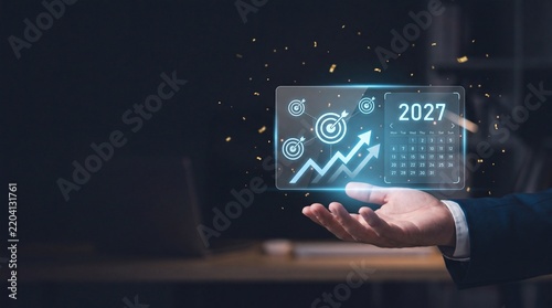 Businessman holding glowing 2027 calendar hologram with growth targets
