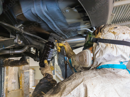 Applying anti-corrosion coating to the underbody of a car using a spray gun
