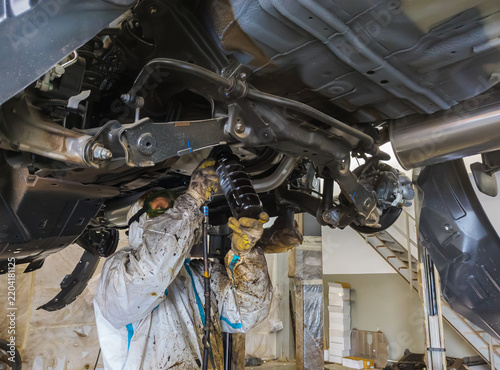 Applying anti-corrosion coating to the underbody of a car using a spray gun