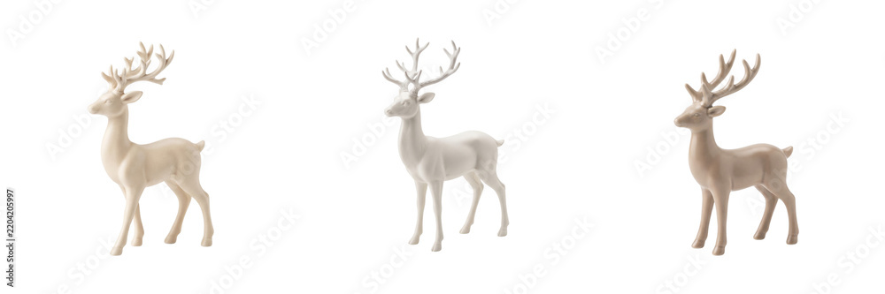 Obraz premium Three white ceramic reindeer figurines with antlers isolated on a transparent background