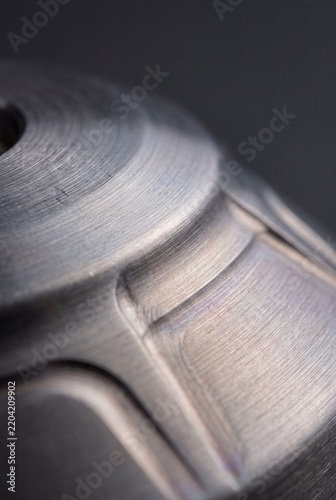 Close-up of machined brushed metal part with circular tool marks
