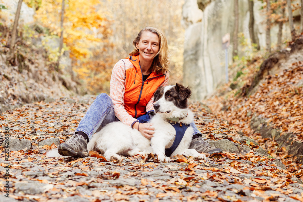 Obraz premium happy white dog with owner in autumn forest