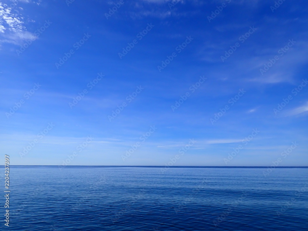Obraz premium Minimal Blue Sky and Waves Horizon. Sea to the horizon and blue sky with clouds, Mediterranean Sea. Aerial view of blue sea and sky landscape. Landscape beautiful summer vertical Horizontal look view.