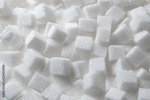 Fotografía Scattered white sugar cubes macro background