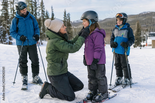 Family preparing for a ski day by putting on winter gear