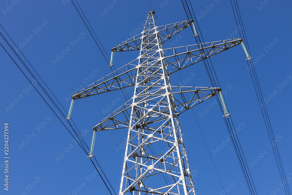 Obraz premium Low angle view of high voltage electric transmission pylon and cables