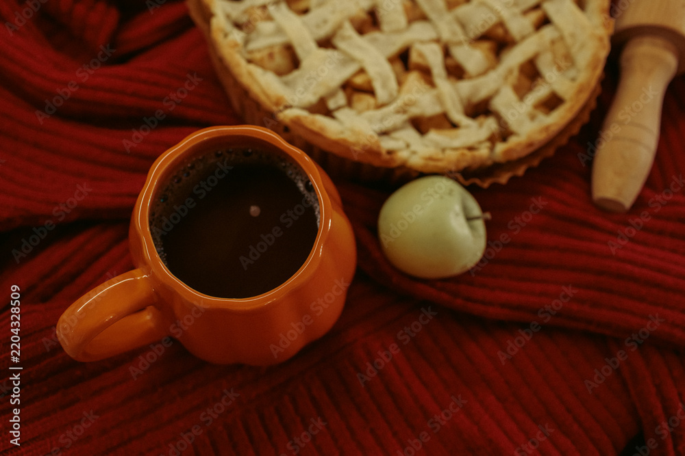 Obraz premium Homemade apple pie with a lattice top next to a cup of hot coffee and an open book, autumn leaf decor, cozy autumn reading setting, film grain effect, high-quality photo